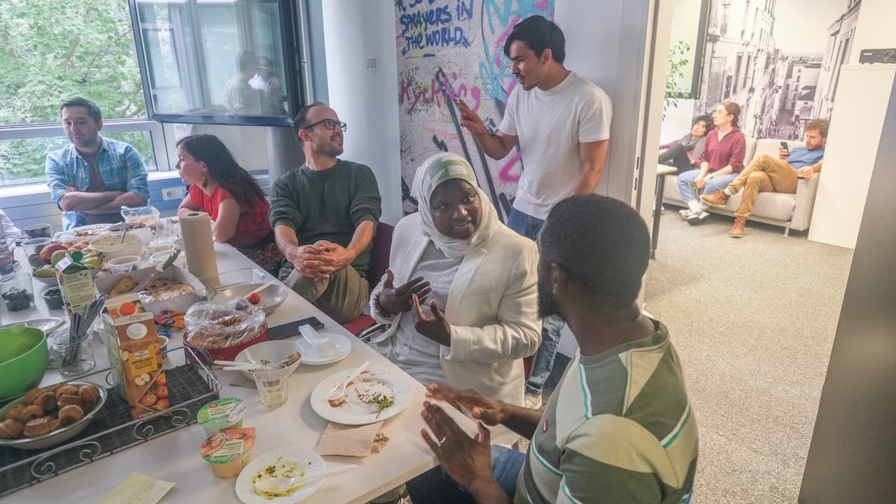 A group of people eating and socialising in a flat